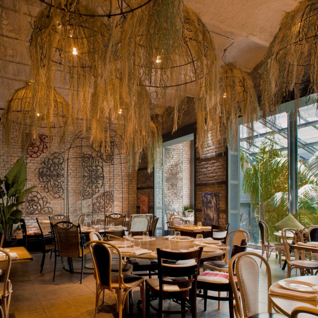 Diseño de restaurante con interiorismo cálido y vegetación suspendida – Estudio Inusual